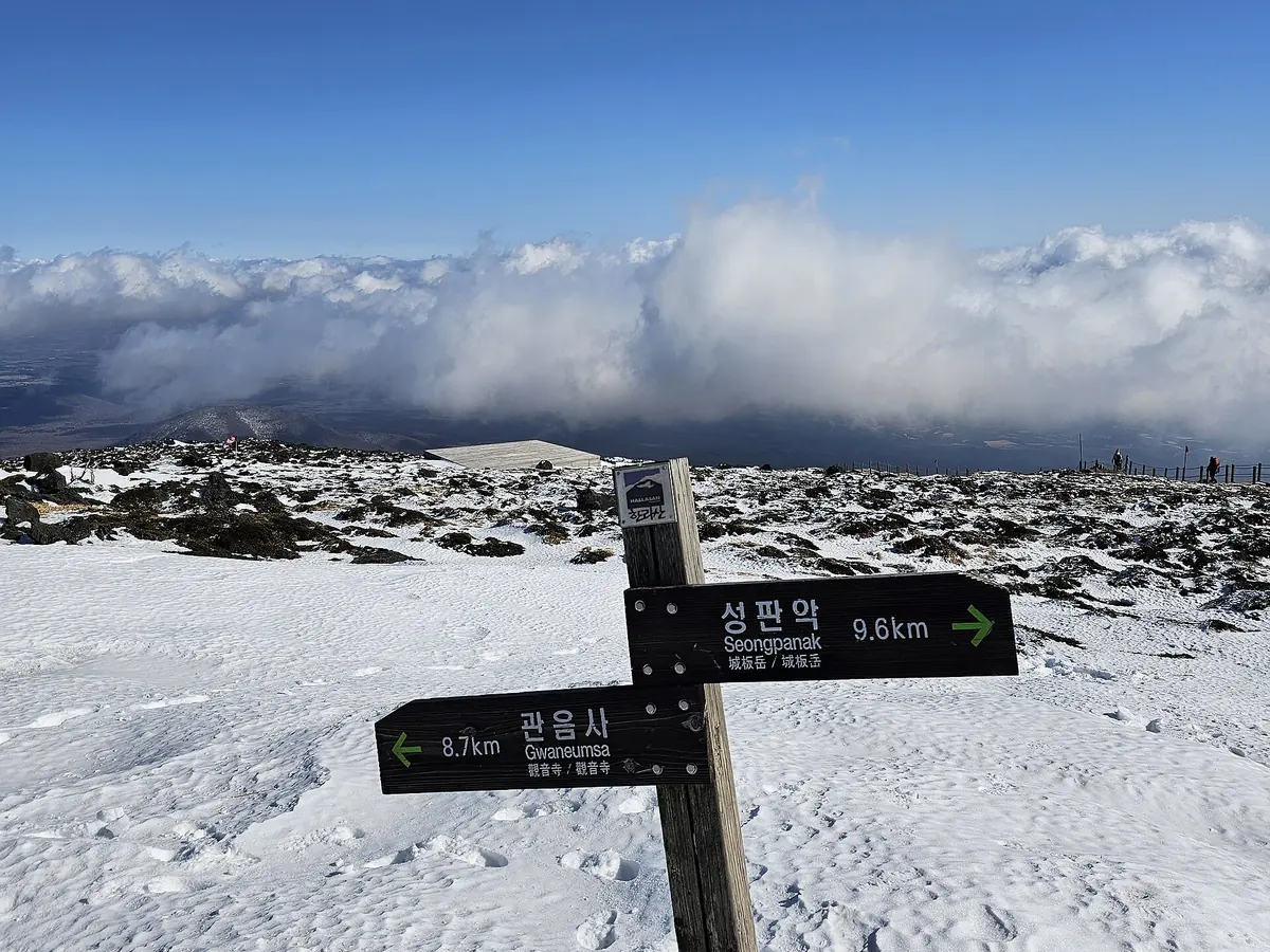 한라산 정상에서 성판악과 관음사 방향을 알려 주는 눈 덮인 이정표